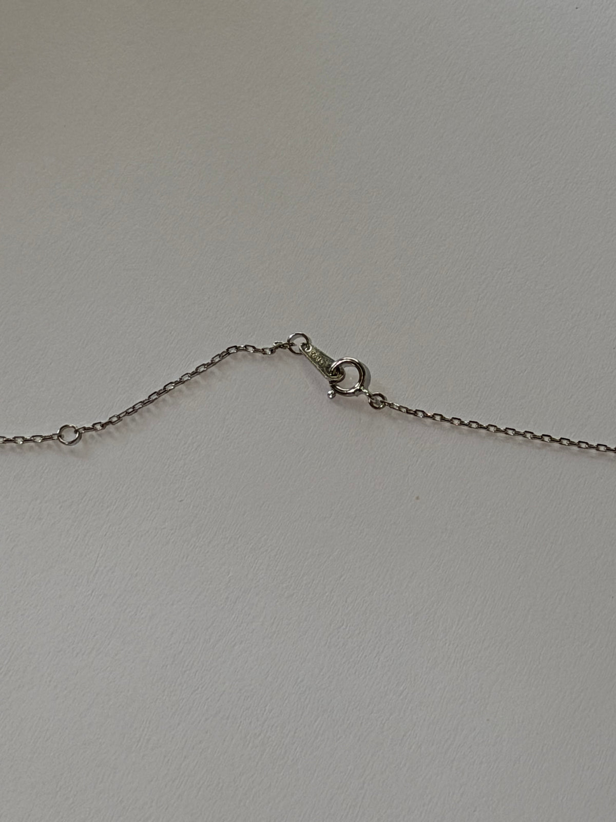 Close-up of French bow pendant with 4 Akoya pearls 6-9mm staggered arrangement 925 silver setting_chain