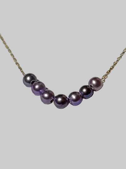 Close-up of smile curve pendant with 7 Akoya pearls 4-5mm graduated arrangement pink purple luster 925 silver