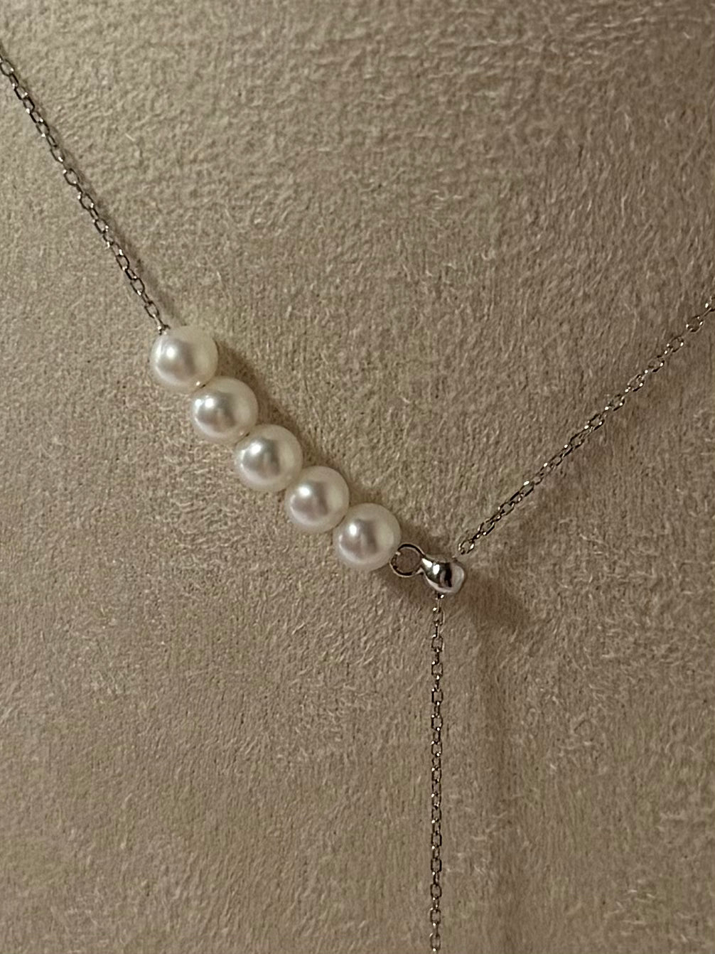 Close-up of teardrop shaped pendant with 6 freshwater pearls graduated size 9-10mm and 4-5mm 925 silver setting