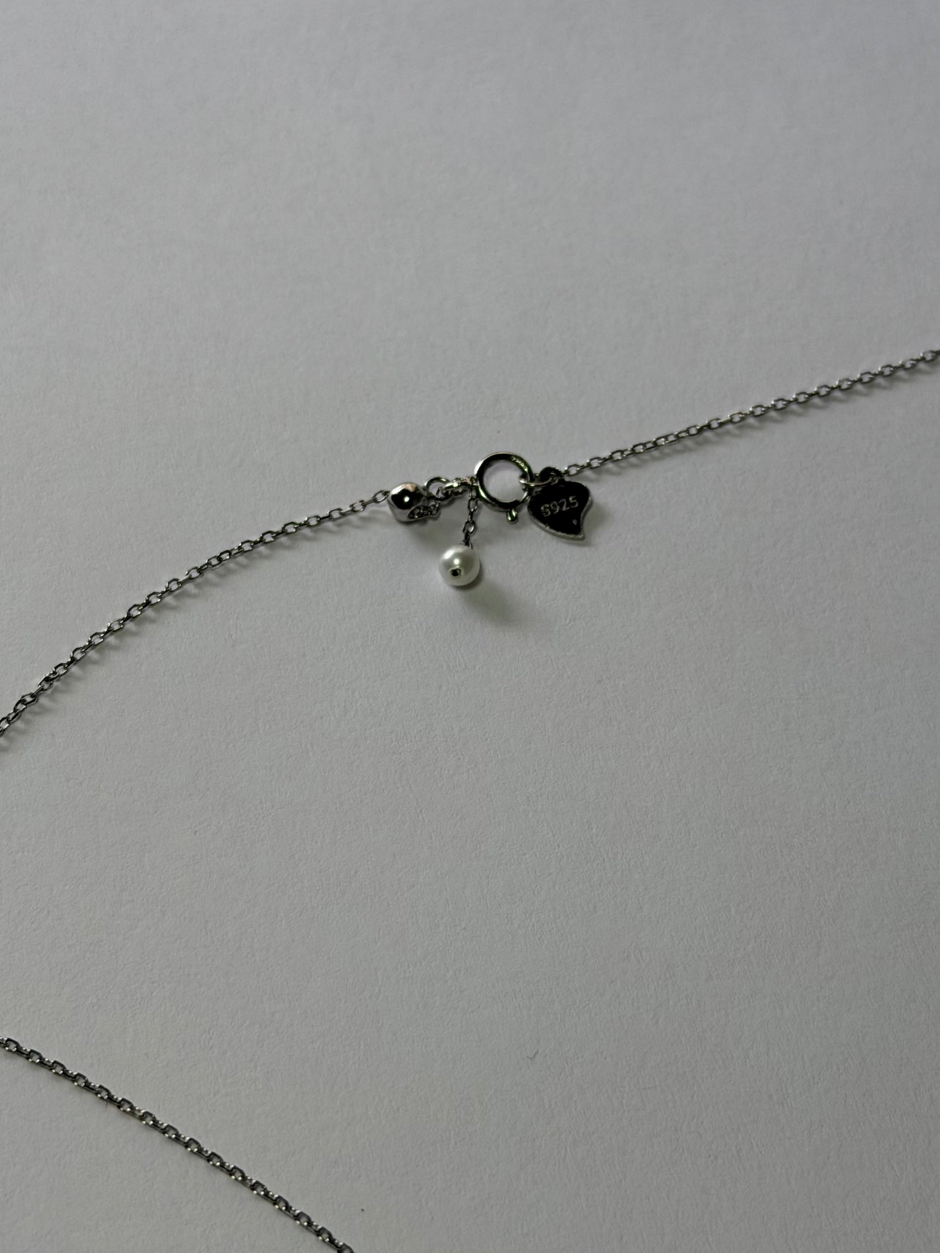 Close-up of teardrop shaped pendant with 6 freshwater pearls graduated size 9-10mm and 4-5mm 925 silver setting_chain